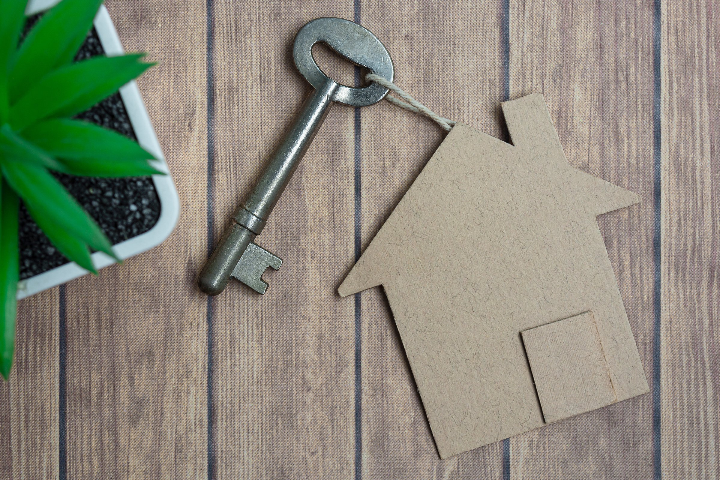 House model and key on wooden desk. Directly above. Flat lay